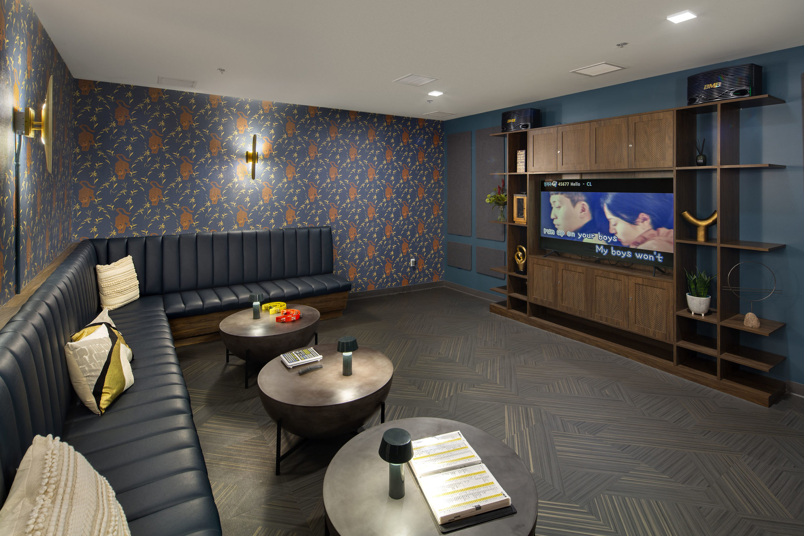 Crosby Apartments resident amenity - Resident lounge with bench seating, tables and big screen TV